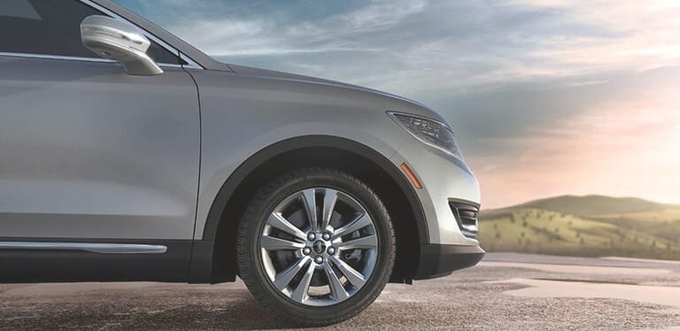 Lincoln vehicle on the road at sunset