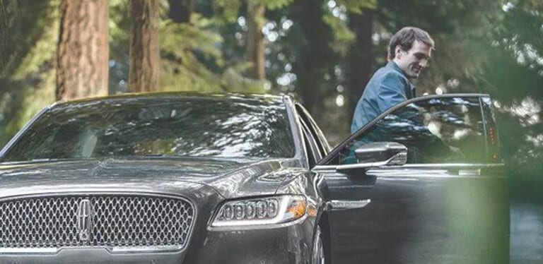 Customer stepping out of a Lincoln vehicle during pickup and delivery service