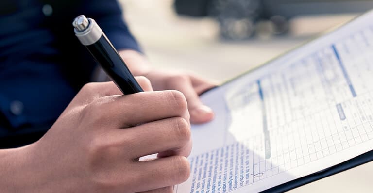 Service technician completing a vehicle inspection checklist.
