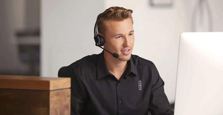 Customer service representative wearing a headset while working at a computer.