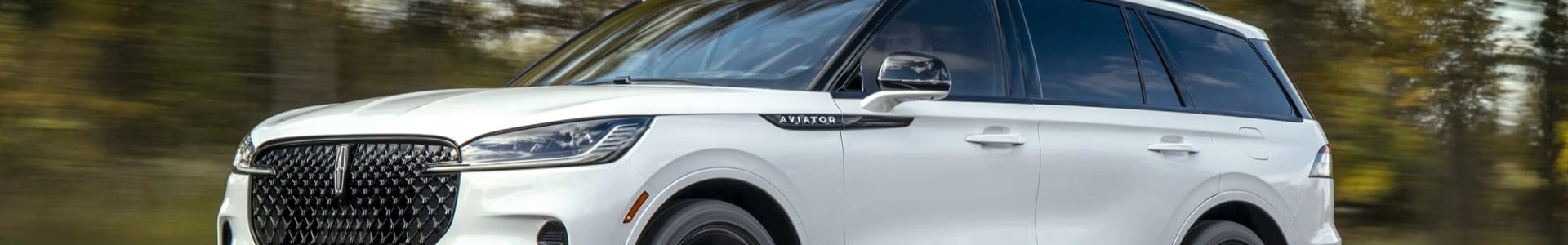 Silver Lincoln Aviator SUV parked, showcasing sleek design and front grille.